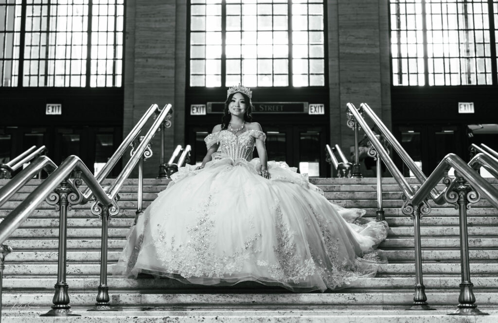 Quinceañera posing on the grand staircase inside Chicago Union Station during her quinceañera photoshoot.